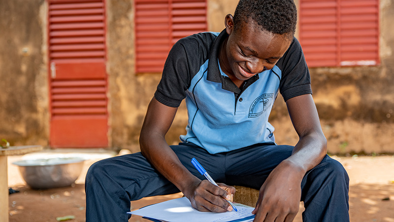 Jongen uit Burkina Faso schrijft een brief aan zijn sponsor.