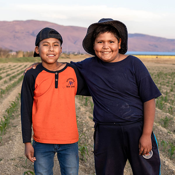 Jhonatan en Hugo uit Bolivia staan buiten in een veld