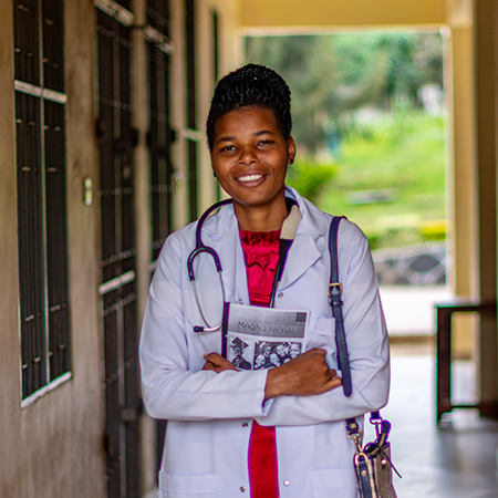 Flomena uit Tanzania studeert om dokter te worden en staat in haar doktersjas op de foto.