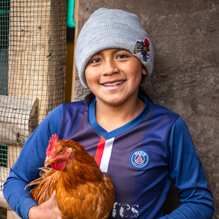 Elian uit Ecuador met een van zijn kippen.