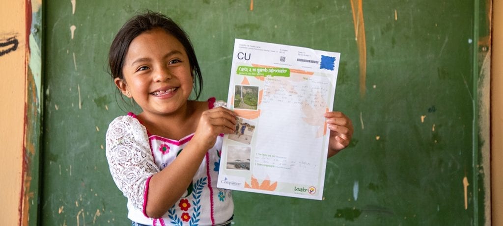 Meisje uit Ecuador laat een brief van haar sponsor zien.