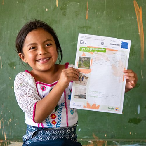 Meisje uit Ecuador laat een brief van haar sponsor zien.