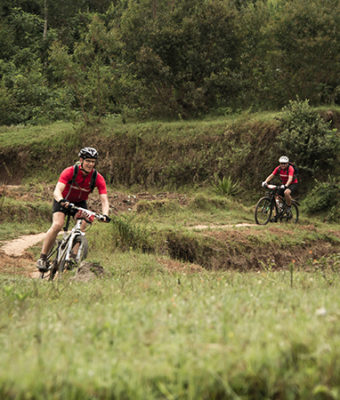 Twee Muskathleten fietsen over een onverhard pad tijdens de Muskathlon.