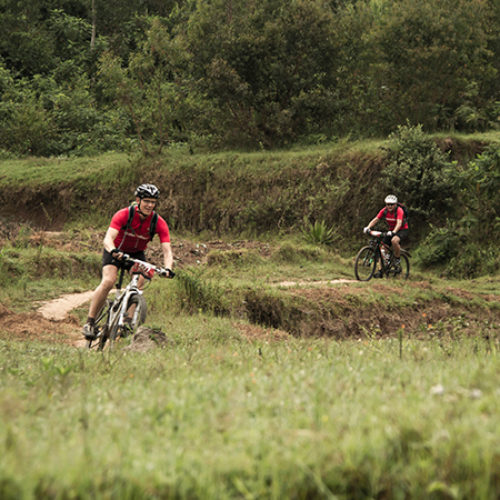 Twee Muskathleten fietsen over een onverhard pad tijdens de Muskathlon.