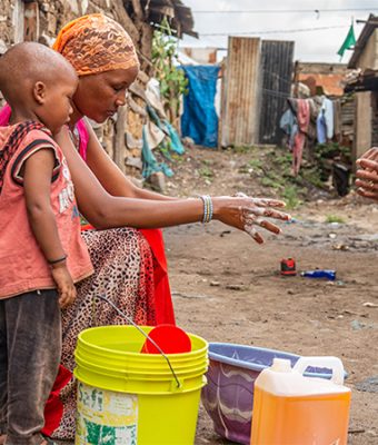Tanzaniaanse moeder en kind wassen handen