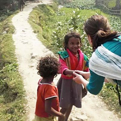 Eline begroet twee kinderen in India.