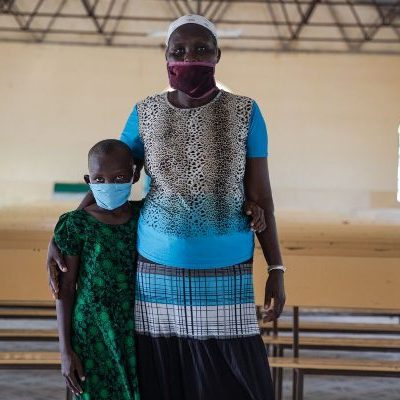 Winnie uit Kenia staat met haar moeder in de kerk.