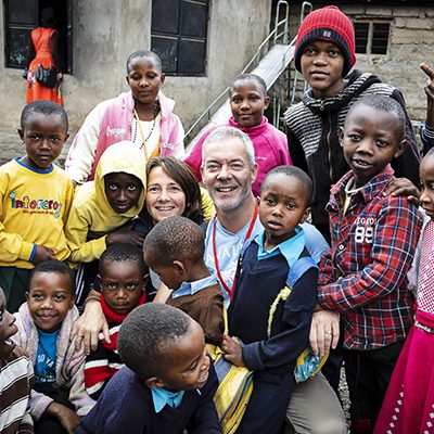 Gert Jan en Marleen van Dommelen staan tussen een groep kinderen tijdens de ondernemersreis in 2010.