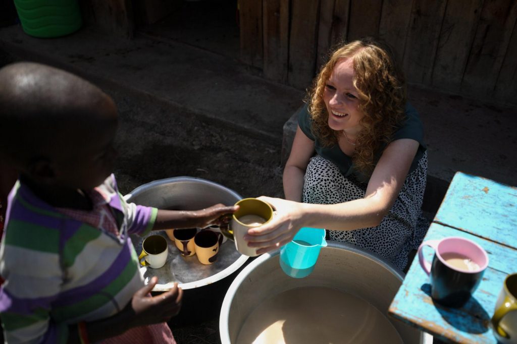 Ambassadeur Cleo helpt bij de maaltijd op een Compassion-porject.