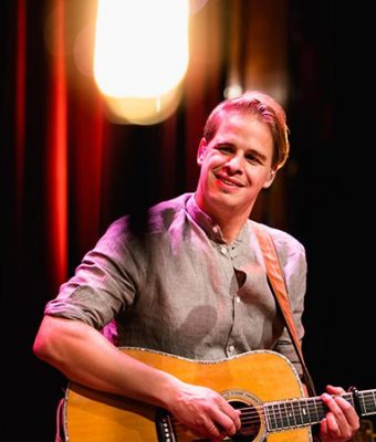 Foto van de Nederlandse liedjesschrijver en zanger Matthijn Buwalda die gitaar speelt.