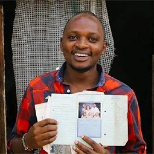 Francis uit Kenia houdt de brieven vast die hij vroeger van zijn sponsor heeft ontvangen.