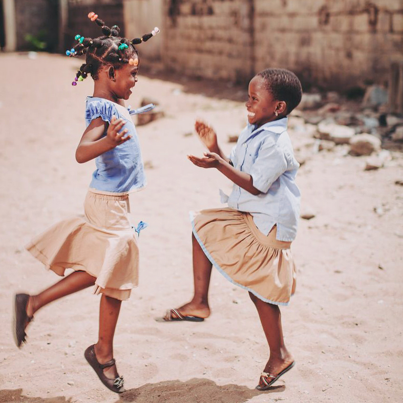 Kinderen uit een Compassion-project in Togo dansen buiten