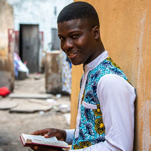 Yves uit Togo staat met zijn Bijbel in zijn hand