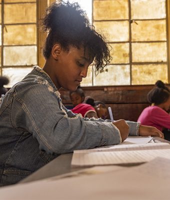 Een meisje schrijft een brief in een Compassion-project in Ethiopië.