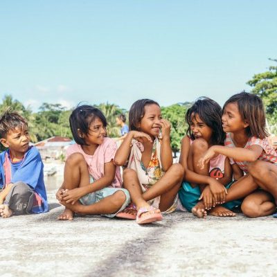 Kinderen in Indonesië zitten op de grond.