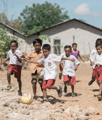 Kinderen uit Indonesië voetballen op straat.