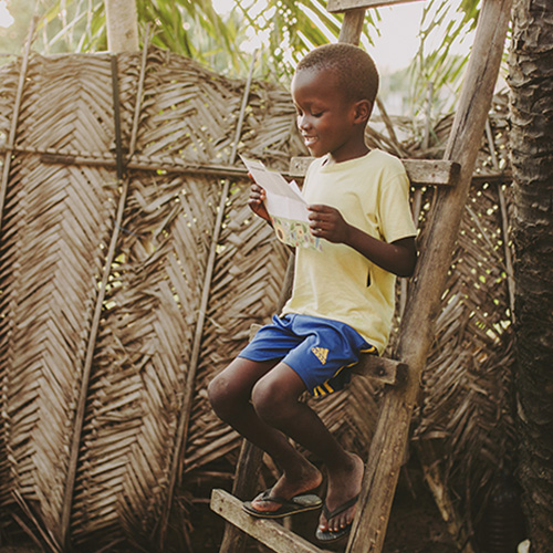 Elvis uit Togo leest een brief die zijn sponsor hem heeft gestuurd.