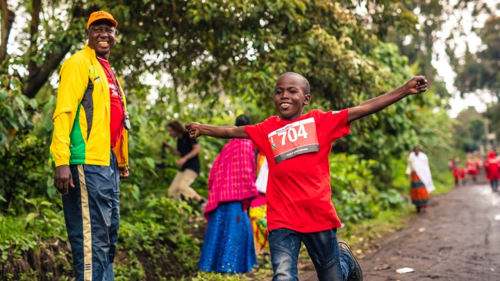 Jongen uit Tanzania rent over de finish tijdens de Muskathlon.