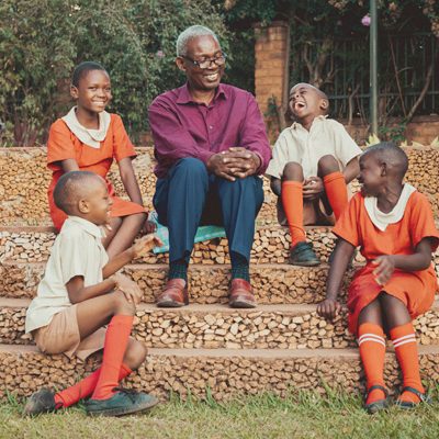 Een pastor en kinderen bij een kerk in Uganda.