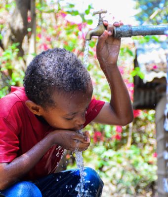 Tensaye uit Ethiopie drinkt water uit een kraan.