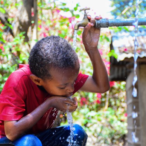 Tensaye uit Ethiopie drinkt water uit een kraan.