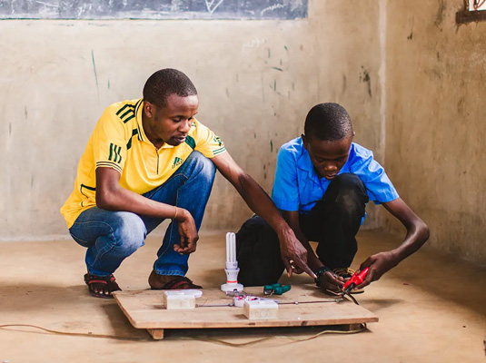 Tanzaniaanse jongen leert elektrisch schakelen.