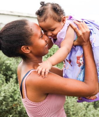 De Braziliaanse moeder Izabelle tilt haar dochter Sophia in de lucht.