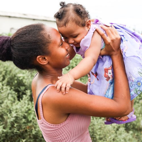 De Braziliaanse moeder Izabelle tilt haar dochter Sophia in de lucht.