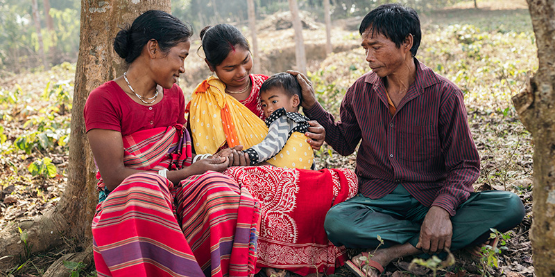 Kohima uit Bangladesh zit op de grond met haar ouders en zoon Joy.