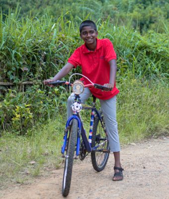 Akshan uit Sri Lanka rijdt op zijn nieuwe fiets.