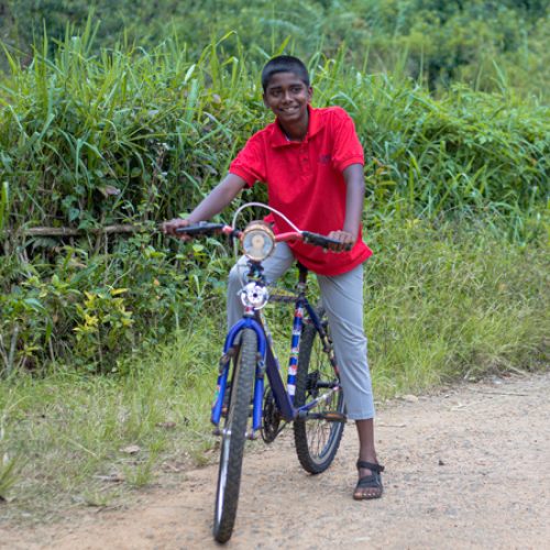 Akshan uit Sri Lanka rijdt op zijn nieuwe fiets.