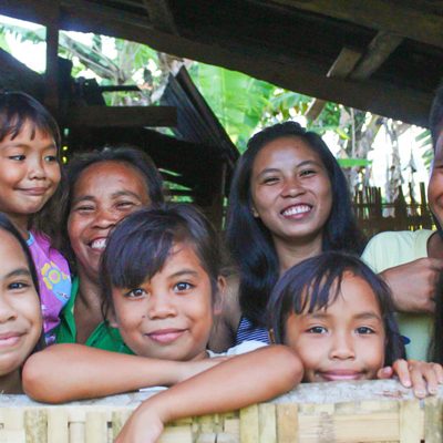 De Filipijnse Raymark staat met een groep vrienden in de deuropening van zijn huis.