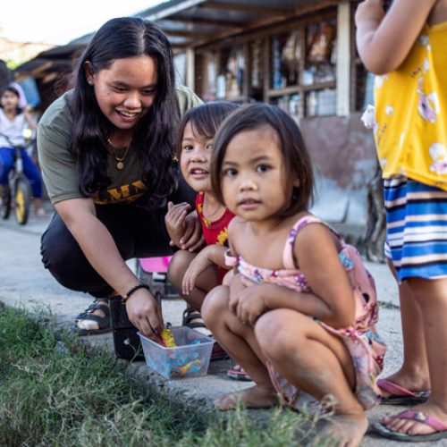 De twintigjarige Jojin uit de Filipijnen speelt met kleine kinderen.