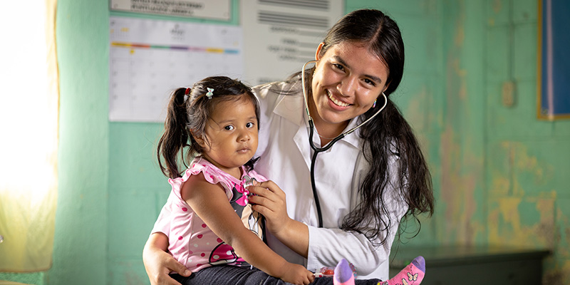 Mariam uit Guatemala controleert een meisje met een stethoscoop. 