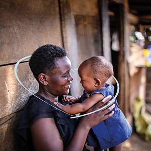 Een Ugandese moeder houdt blij haar baby vast.