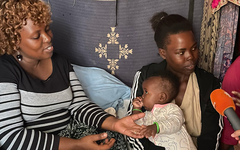 Moeder Maureen uit Uganda wordt in haar huis geïnterviewd met haar baby op schoot.