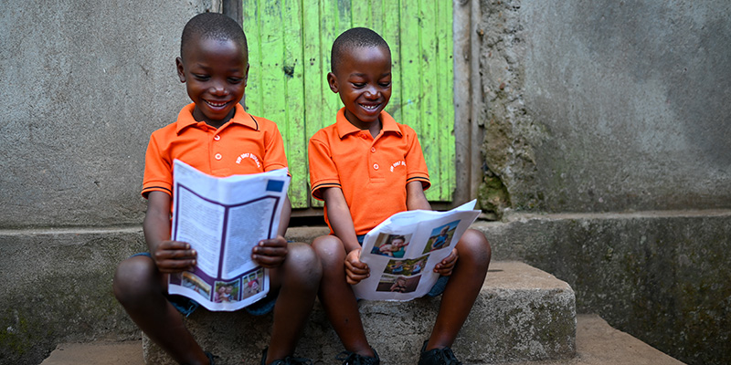 Aime en Aimable uit Rwanda lezen brieven voor hun huis.