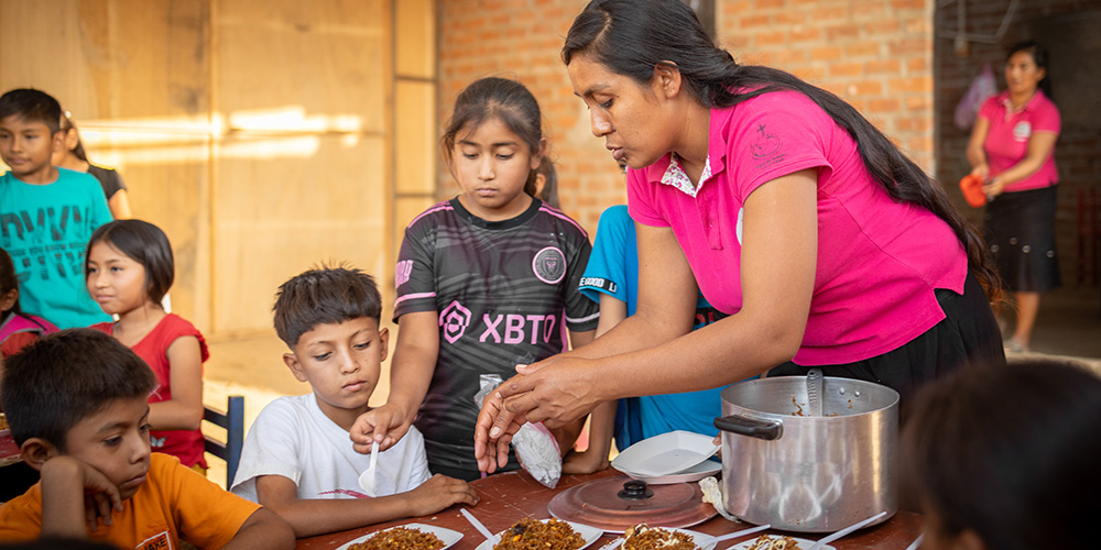 Kinderen krijgen eten op een Compassion-project in Peru.