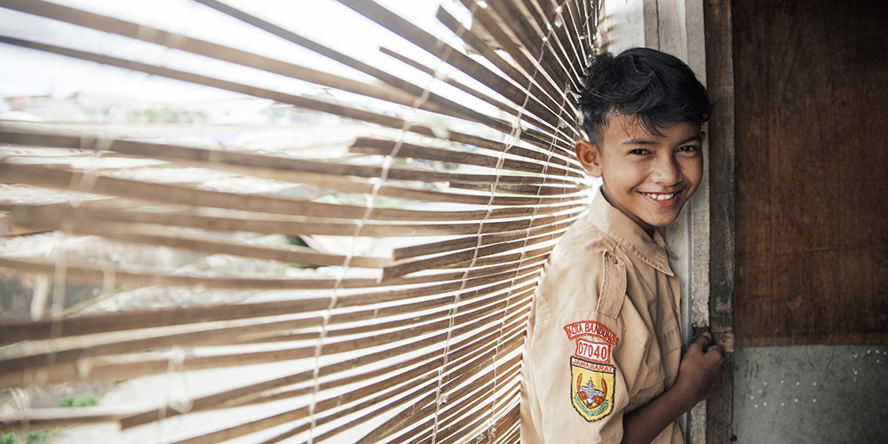 Agung uit Indonesië staat voor het raam.