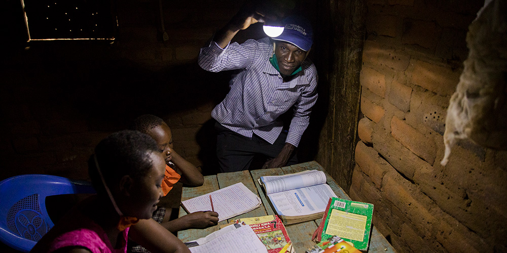 Kinderen uit Kenia maken huiswerk met de solar lamp.