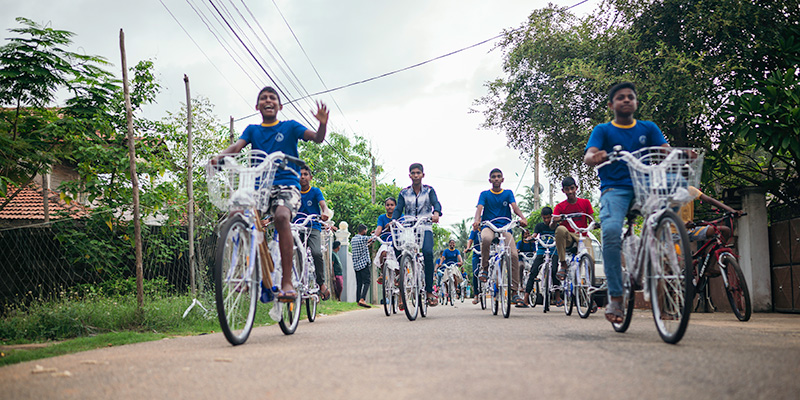 Tieners uit Sri Lanka fietsen over de weg.