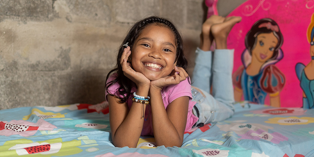 Sofy uit Colombia ligt op bed.
