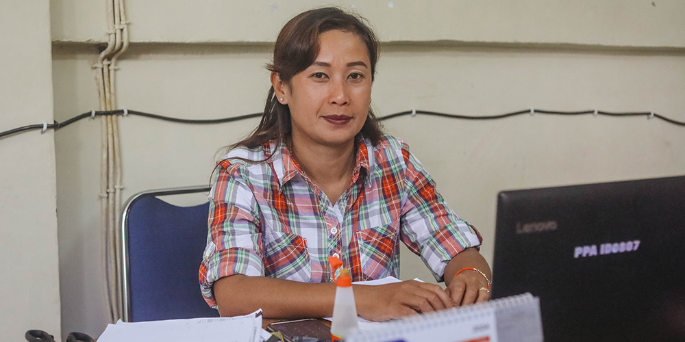 Accountant Ati uit Indonesië zit achter een computer. 