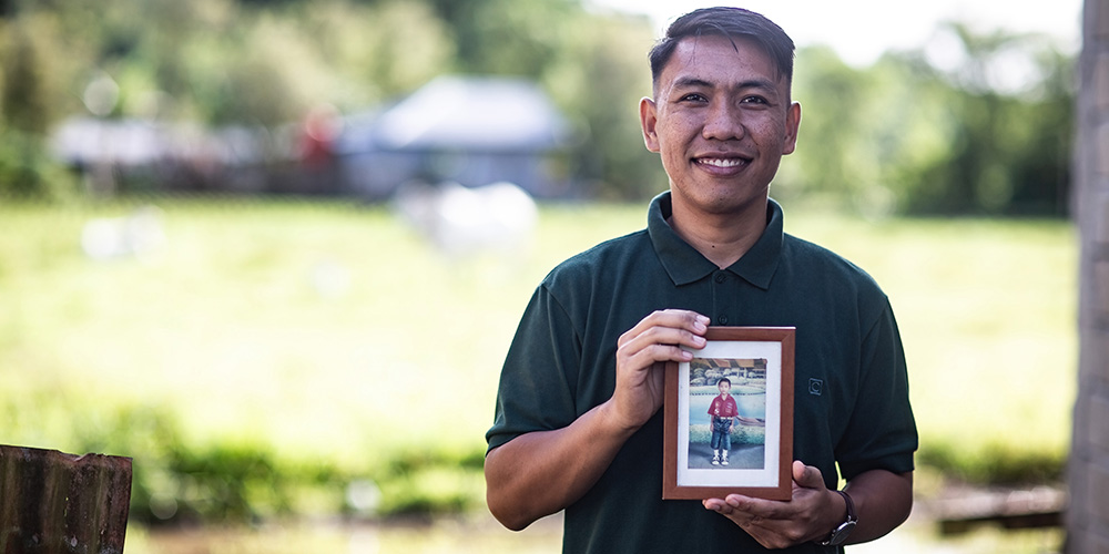 Frizky uit Indonesië houdt een kinderfoto van zichzelf vast.