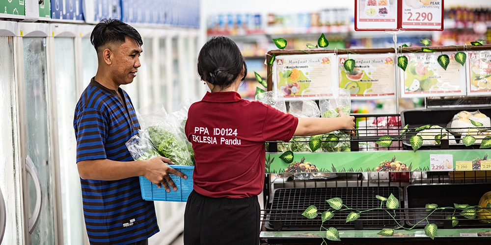 Frizky uit Indonesië staat voor een supermarktschap met de groenten uit zijn hydrocultuurtuin.