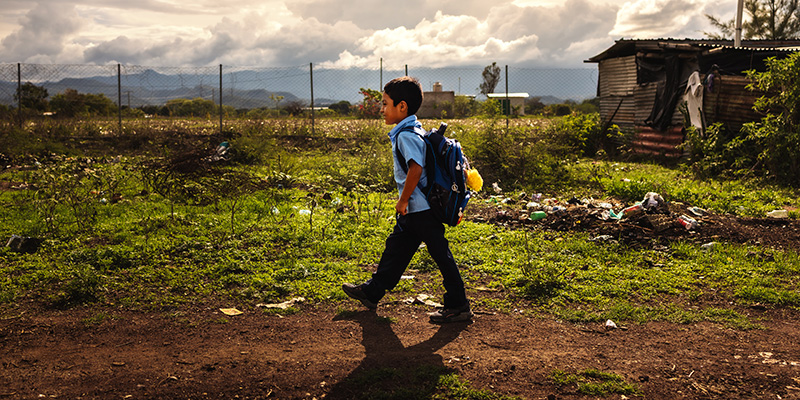 Anderson uit Guatemala loopt naar school met zijn rugtas. 