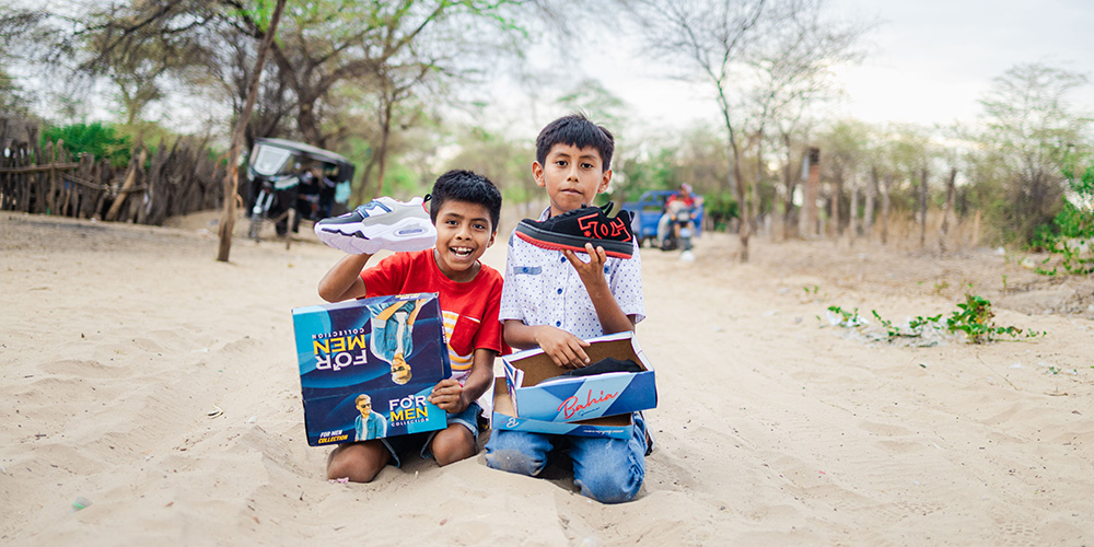 Emanuel en Emanuel uit Peru laten hun nieuwe schoenen zien.
