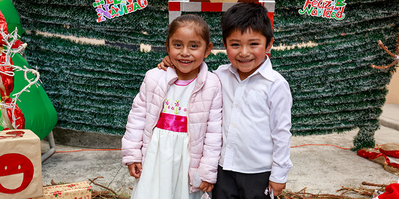 Kenia en Mateo kijken in de camera tijdens het kerstfeest op het project.