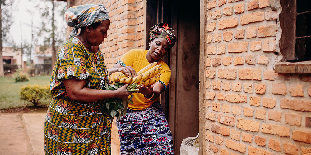 Twee vrouwen uit Rwanda met bananen in hun hand. 