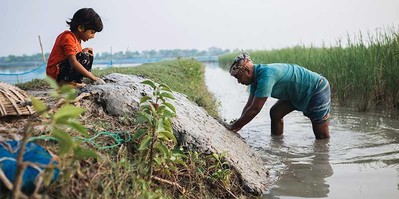 Sneha uit Bangladesh speelt terwijl haar vader werkt.